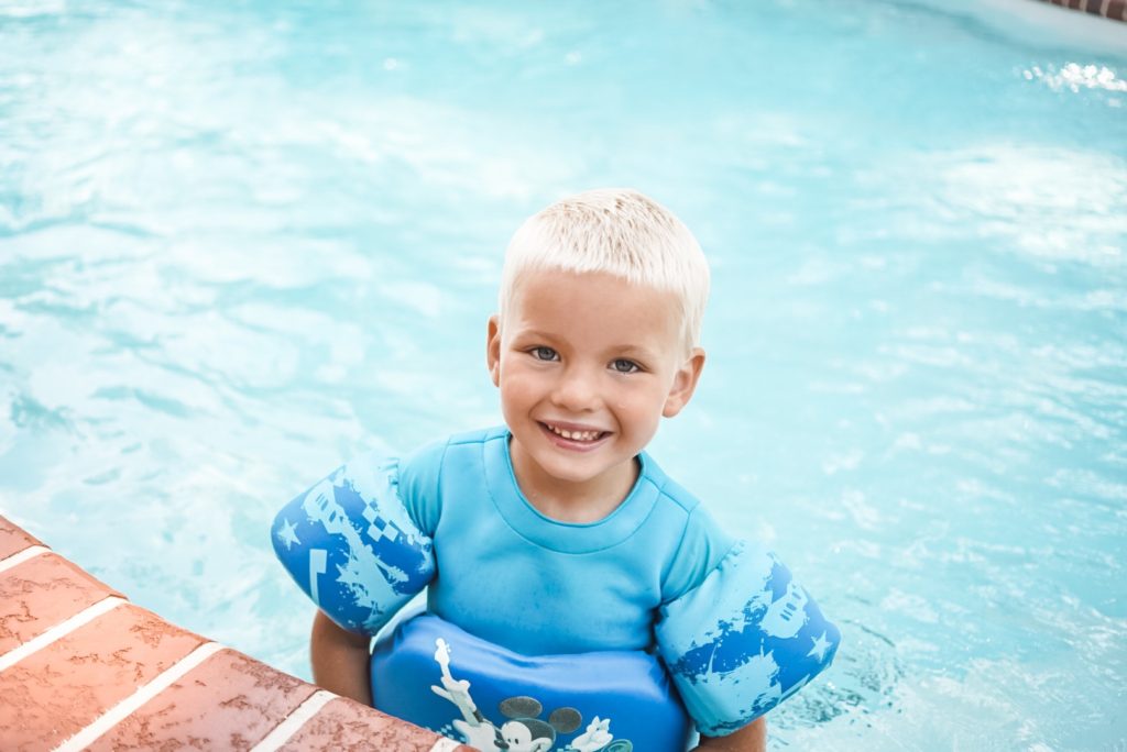 Boy smiling at camera in a swimming pool 