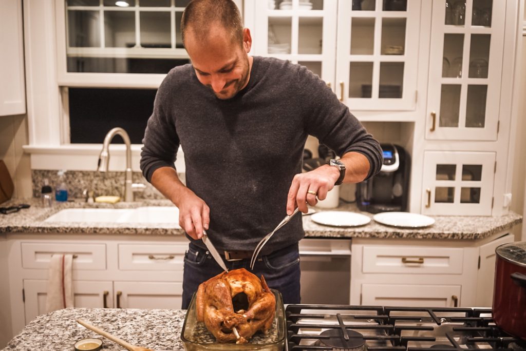 Man cutting turkey on kitchen counter