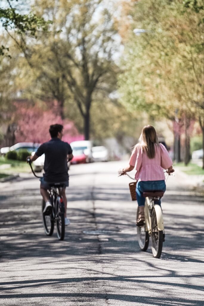 Girl in pink shirt riding yellow bike next to boy with navy blue shirt riding bike